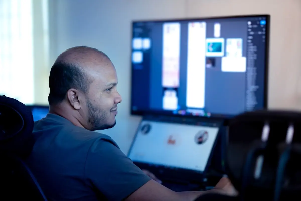 people sitting on chair in front of computer monitor
